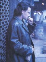 Bono standing next to wall